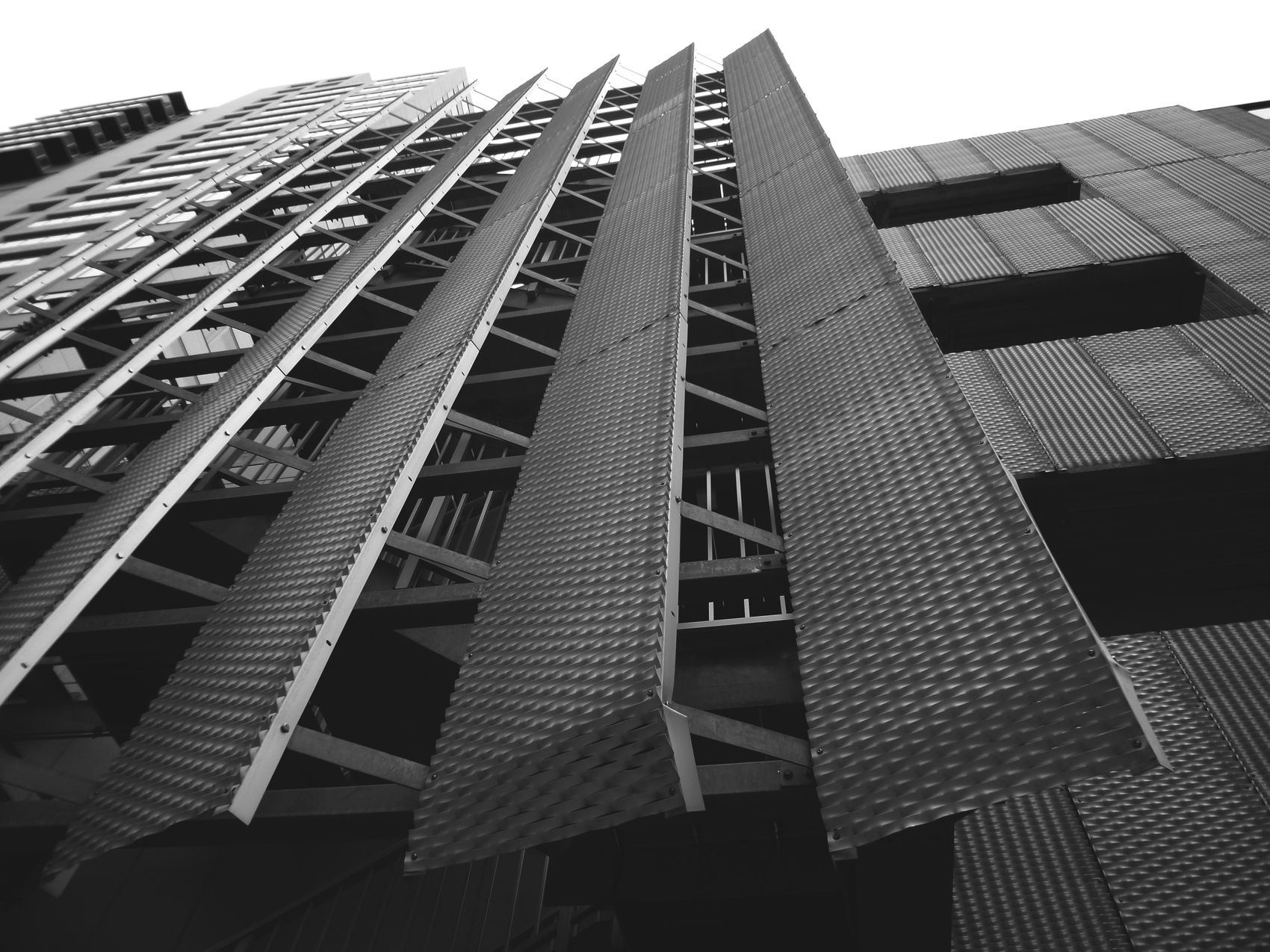 A striking black and white photo of a futuristic building facade with metal texture and geometric design.